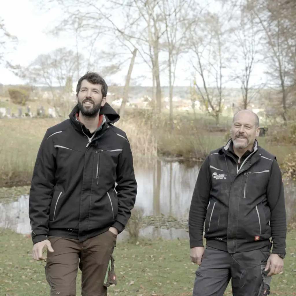 Georg Hilligardt (links) und Jens Hartmann (rechts) auf der Wiese vor dem Teich der Anlage